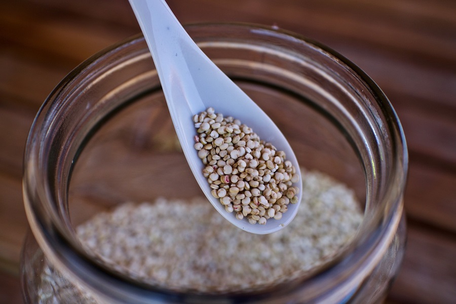 Easy Quinoa Recipes for Diabetics Close Up of a Small Spoon Filled with Quinoa Hovering Over a Glass Jar of Quinoa