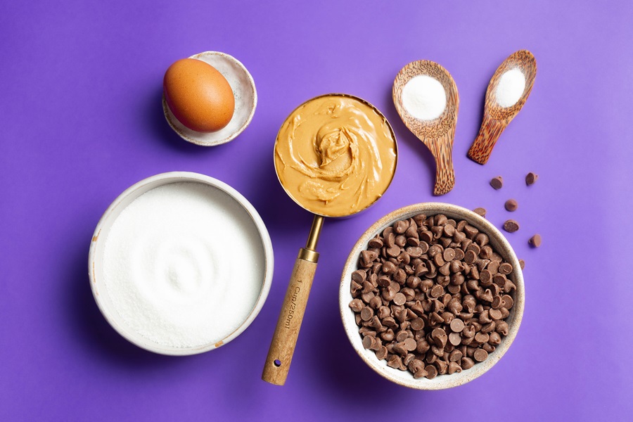 Air Fryer Peanut Butter Cookies without Flour Ingredients Separated into Small Bowls on a Purple Surface