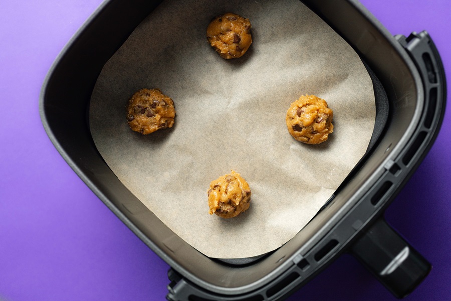 Air Fryer Peanut Butter Cookies without Flour Raw Cookie Dough Balls on Parchment Paper in an Air Fryer Basket