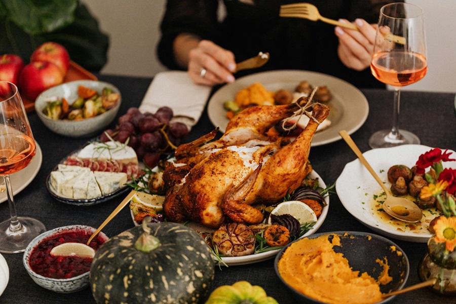 Healthy Leftover Turkey Recipes Close Up of a Turkey on a Table with People Eating 