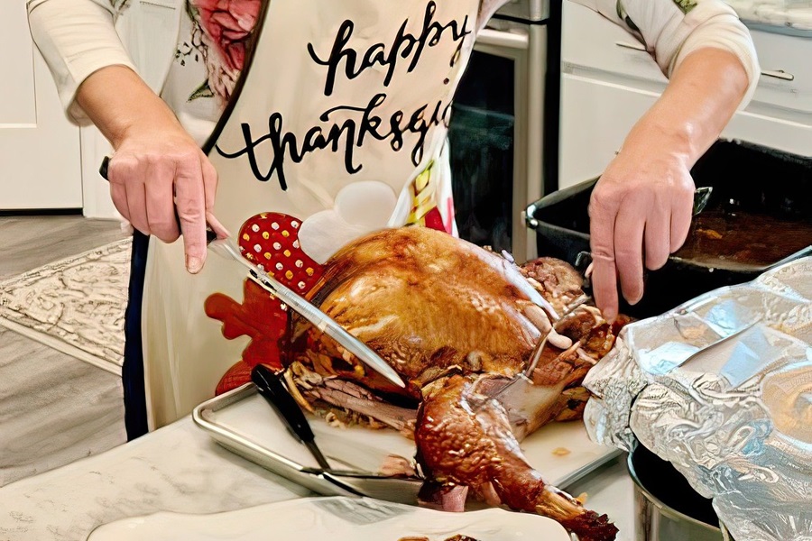 Healthy Leftover Turkey Recipes Close Up of a Person Carving a Turkey on a Kitchen Counter