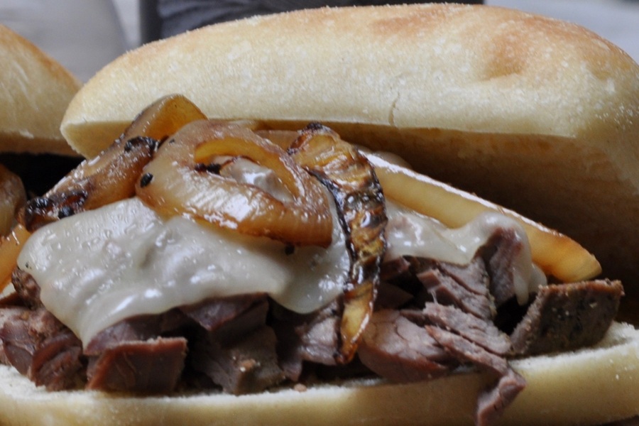 Very Close Up of Shredded Beef Sandwiches  with Cheese and Grilled Onions