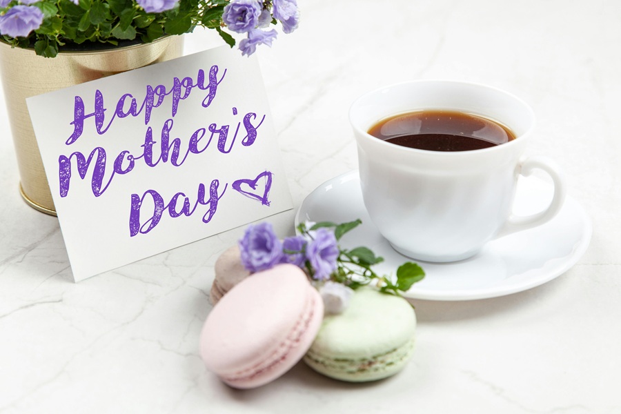 Healthy Mothers Day Breakfast Ideas Close Up of a Card That Says Happy Mother's Day Next to a Cup of Coffee and Two Macaroons