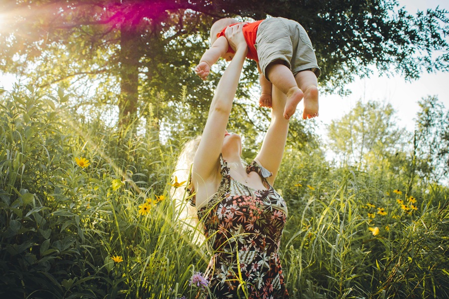 Healthy Mothers Day Breakfast Ideas a Mom Sitting in Tall Grass Lifting Her Baby into the Air