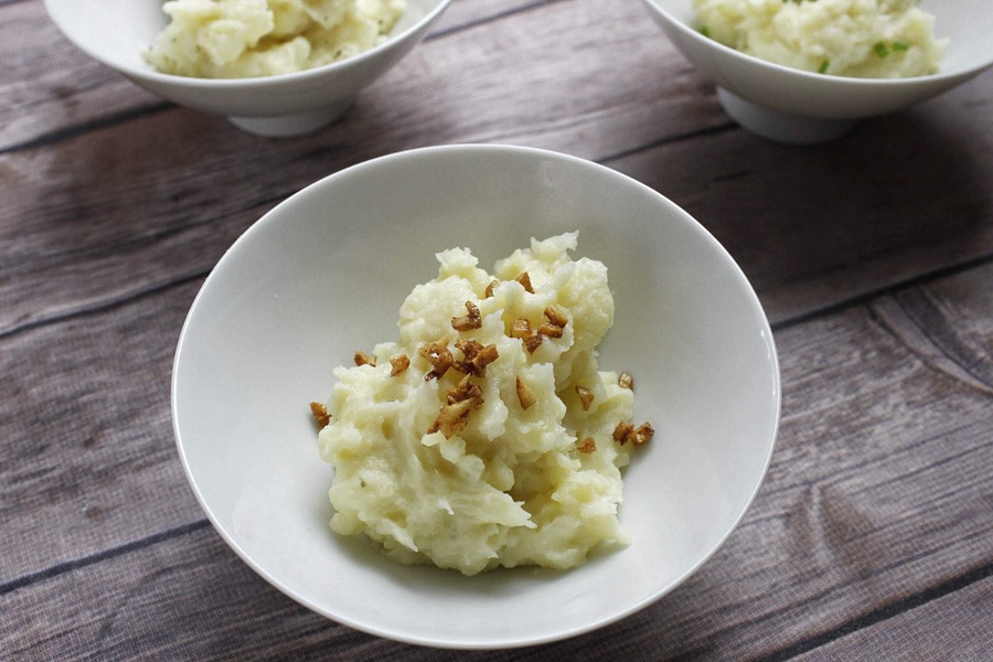 15 Minute Instant Pot Mashed Potatoes Close Up of Three Bowls Filled with Mashed Potatoes and Each Topped with a Different Garnish Including Bacon, Chives, and Cheese