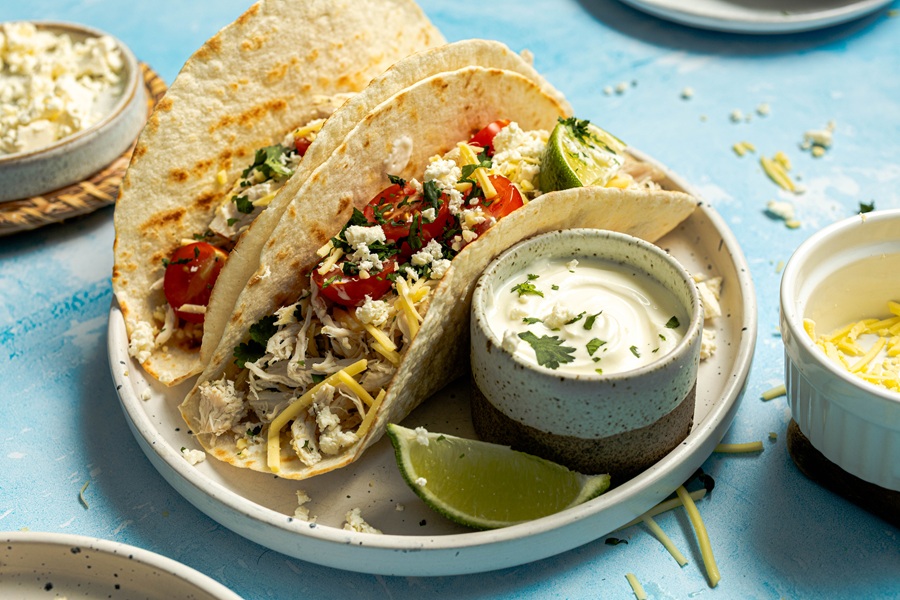 Easy Chicken Tacos with Shredded Chicken a Plate of Tacos with a Small Ramekin of Sour Cream