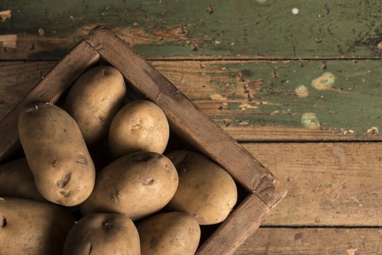 Baked Potatoes in the Oven a Wooden Crate of Potatoes on Wooden Planks