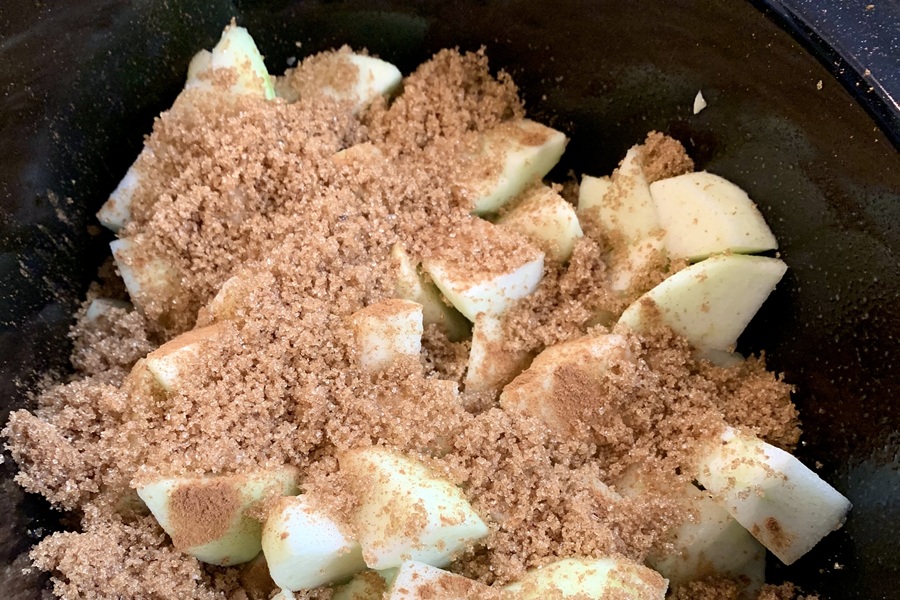 Crockpot Apple Crisp Apples in Crockpot Covered in Cinnamon and Brown Sugar
