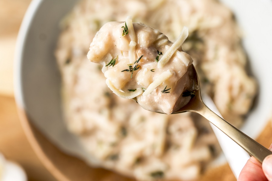 Easy Leftover Turkey and Noodles Recipe Close Up of a Spoonful of Casserole Hovering Over a Bowl of Casserole