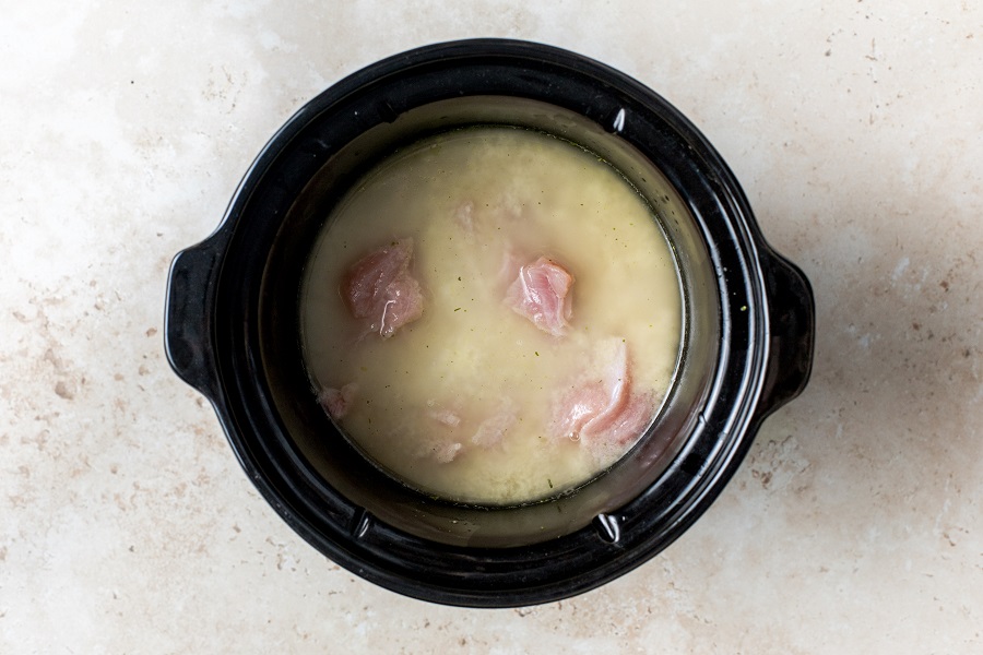 Easy Leftover Turkey and Noodles Recipe Overhead View of a Crockpot with Turkey and Chicken Stock Inside