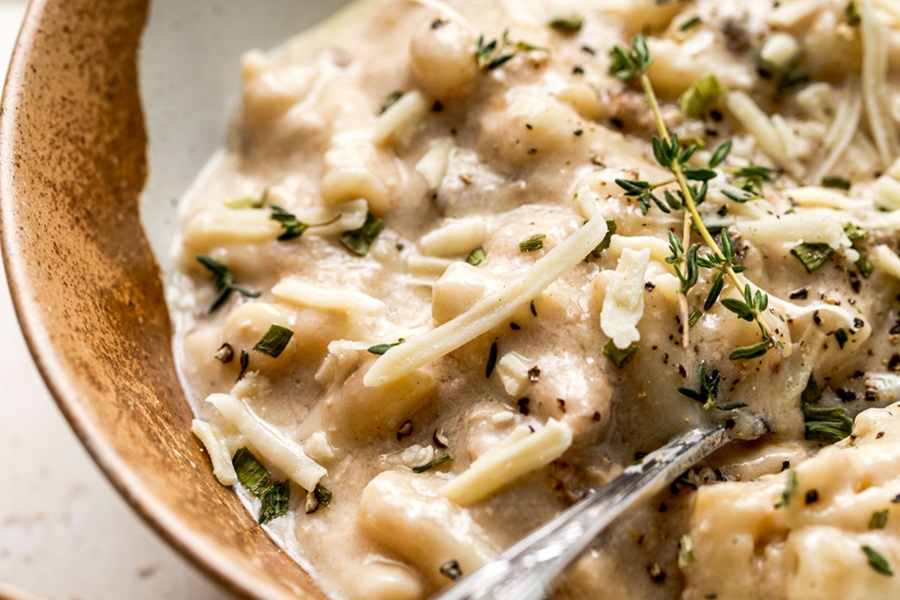 Easy Leftover Turkey and Noodles Recipe a Bowl of Casserole with a Spoon Topped with Thyme