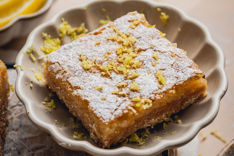 Lemon Bar Recipe Close Up of a Lemon Bar on a Plate