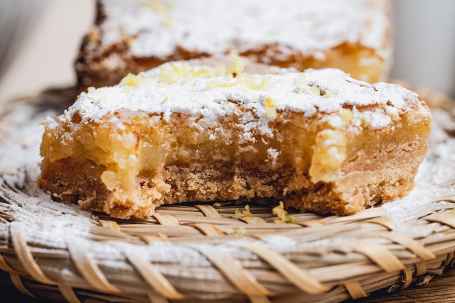 Lemon Bar Recipe Close Up of a Lemon Bar with a Bite Taken From it