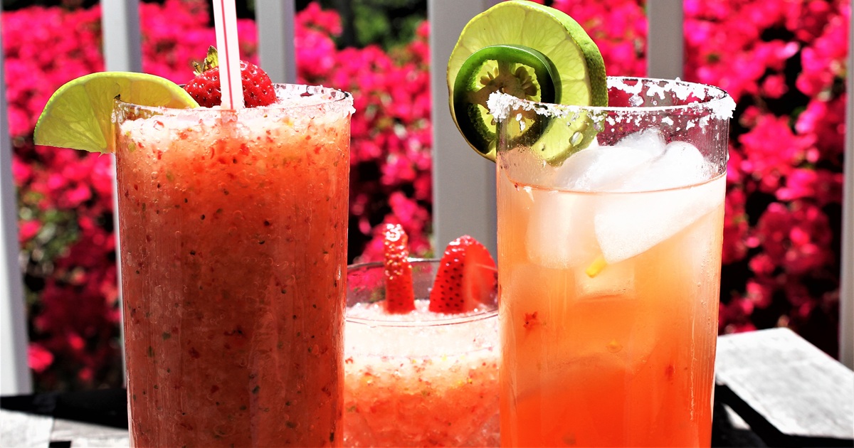 National Margarita Day Recipes Two Strawberry Jalapeno Margaritas Garnished with Jalapenos and Lime Slices On a Table Outside
