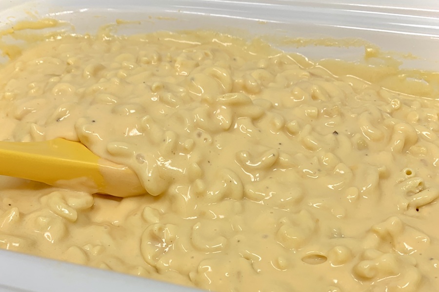 Simple Macaroni and Cheese Recipe Close Up of Macaroni and Cheese Inside a Crockpot with a Yellow Spoon Inside