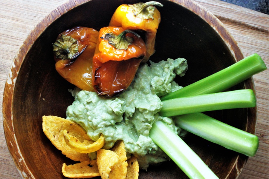 Easter Appetizers a Bowl of Goat Cheese Guac with Peppers, Chips, and Celery Sticks