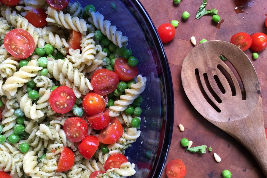 Easter Appetizers a Blue Glass Bowl Filled with Pesto Pasta Salad and a Wooden Serving Spoon Next to it