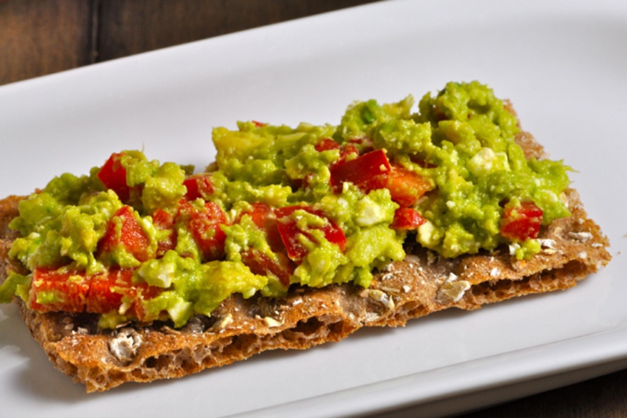 Easter Appetizers Close Up of Crispbread Topped with Guacamole on a White Plate