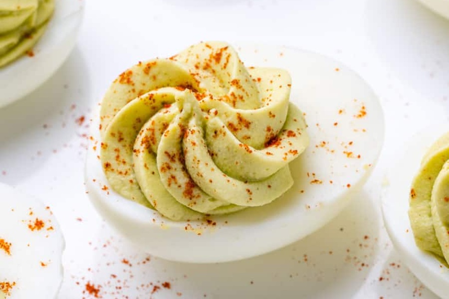 Healthy Easter Dinner Side Dishes Close Up of a Deviled Egg with Avocado Sprinkled with Paprika