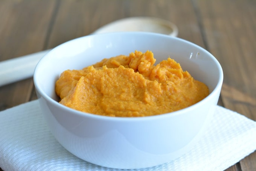 Healthy Easter Dinner Side Dishes a Bowl of Mashed Sweet Potatoes on a Wooden Table