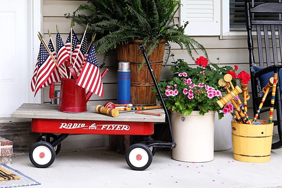 4th of July Party Ideas a Porch with a Red Wagon Next to Planters with a Small Bucket of American Flags 