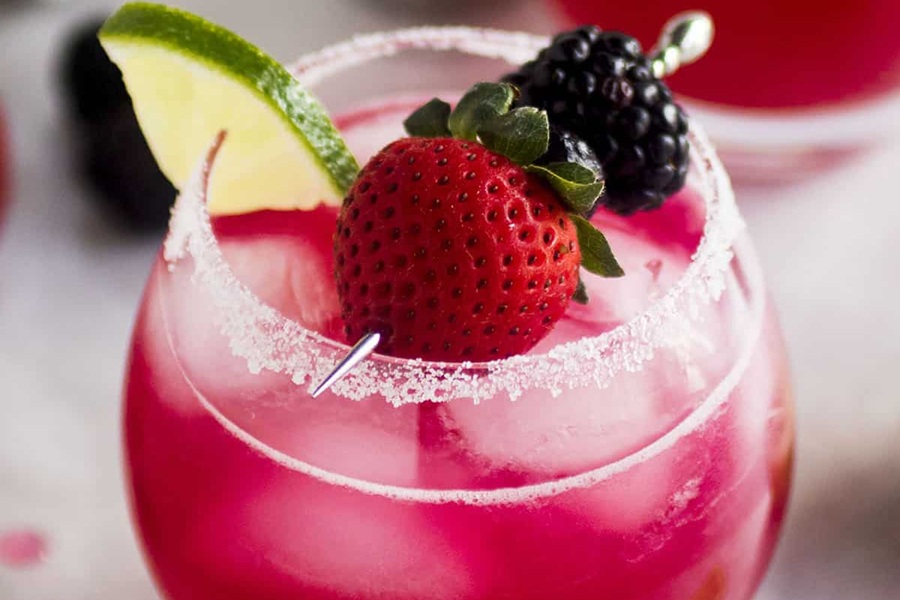 Summer Margarita Recipes Close Up of Triple Berry Margarita Garnished with a Strawberry and a Blackberry