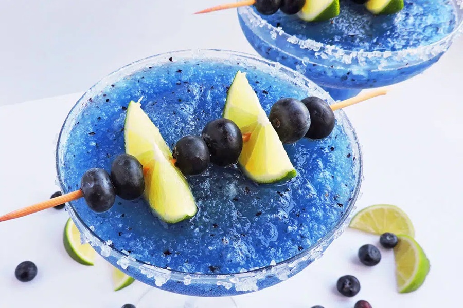 Summer Margarita Recipes Fresh Frozen Blueberry-Lime Margarita Garnished with Lime Wedges and Blueberries