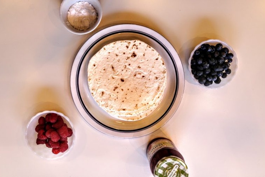 Patriotic Dessert Recipes Fruit Crisp Recipe in the Air Fryer Tortillas on a Plate Next to Bowls of Berries