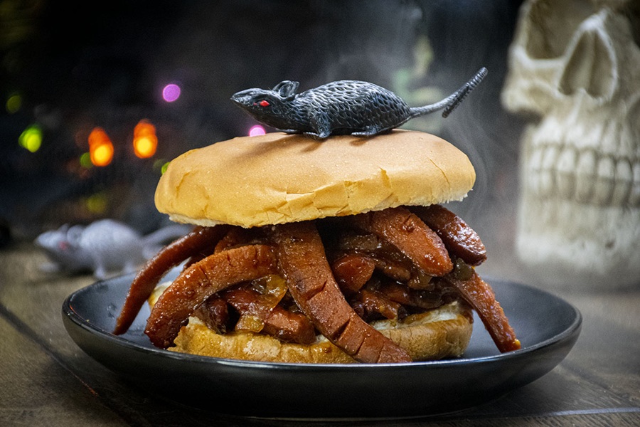 Crockpot Halloween Recipes Close Up of a Hot Dog Sandwich with a Plastic Rat on Top