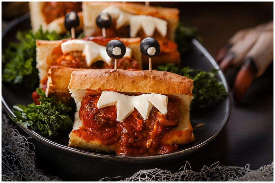 Crockpot Halloween Recipes Meatball Sandwiches with Olives as Eyes on Toothpicks and Cheese Cut into Teeth Shapes