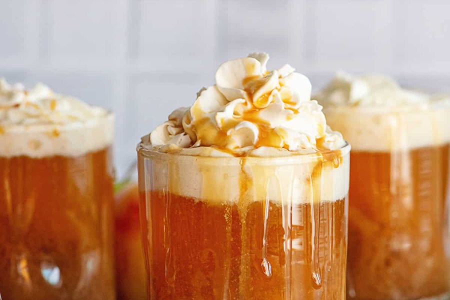 Crockpot Halloween Recipes with Apples Close Up of Caramel Apple Cider in Glasses Topped with Whipped Cream
