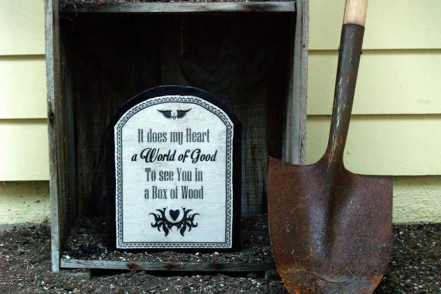 DIY Halloween Decorations A Fake Tombstone Sitting in a Wooden Crate Next to a Shovel Outside a Home