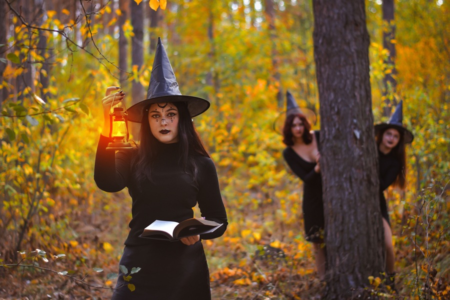 Downloads for your Halloween Playlist Girls Dressed as Witches Standing in a Forest