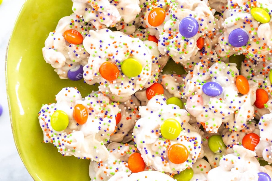 Spooky Halloween Crockpot Recipes Small Candy Clsuters Dusted with Sprinkles and Orange, Yellow, and Purple Candies