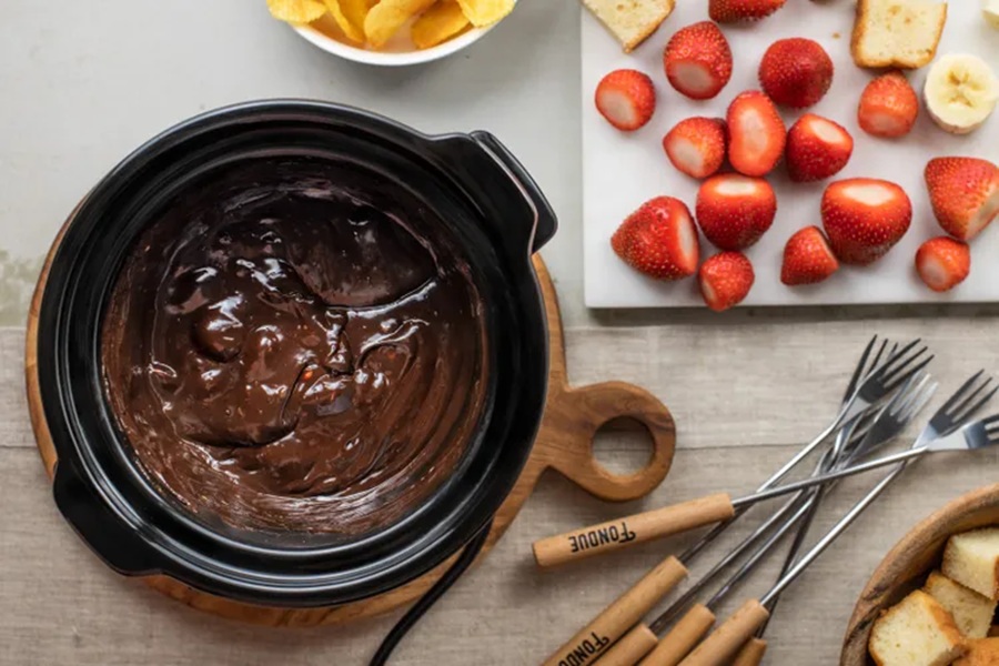 Spooky Halloween Crockpot Recipes a Crockpot Insert Filled with Melted Candy Chocolate Bars Next to a Platter of Diced Fruit and Fondue Sticks